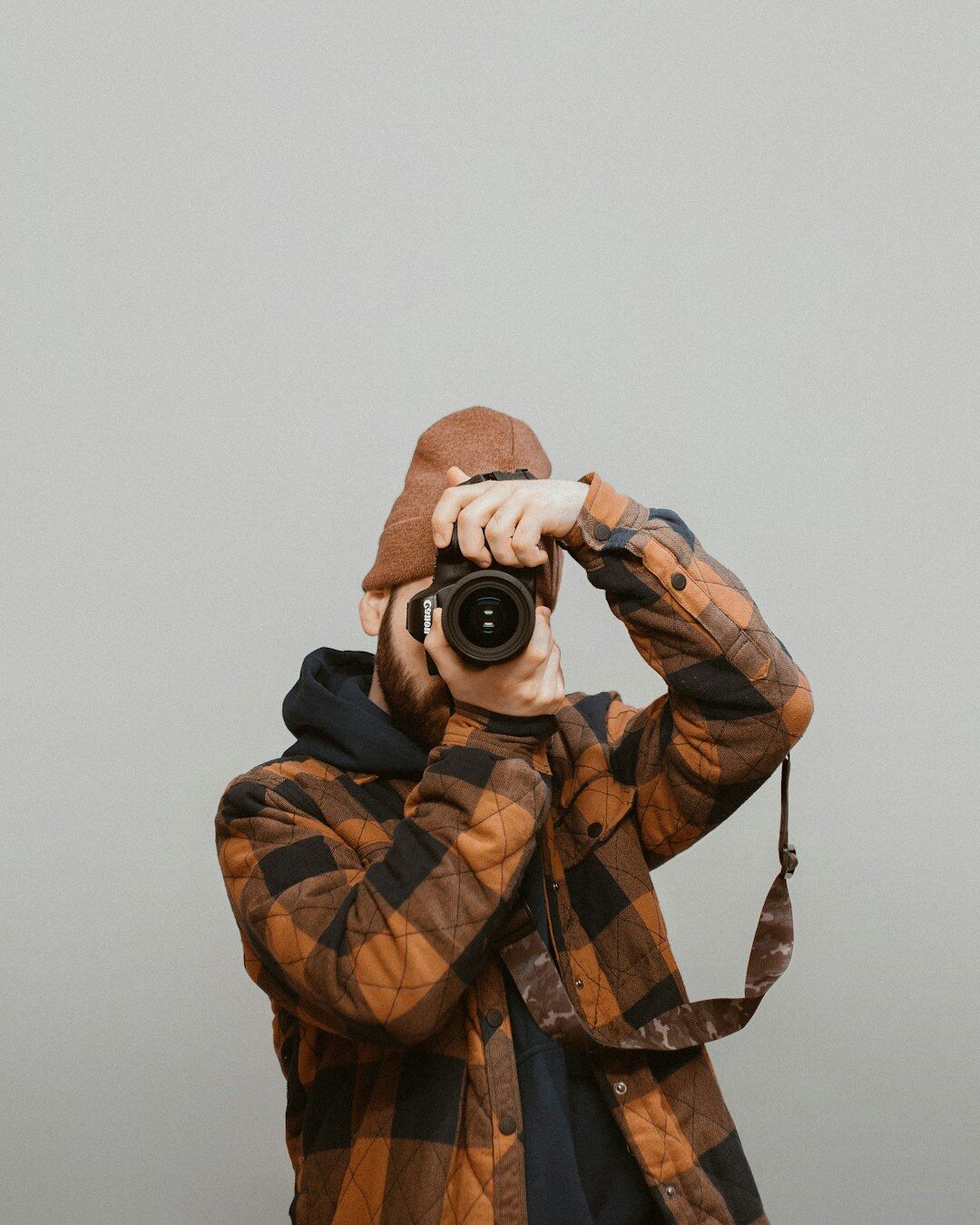 Photographer holding a professional camera in a studio