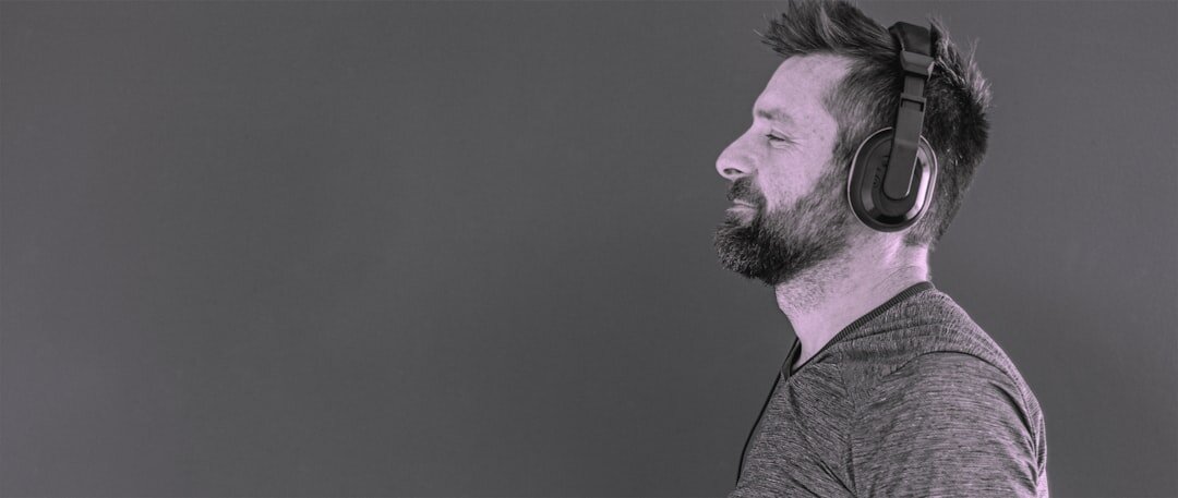 Studio portrait of a bearded Finnish man in his forties wearing a headset