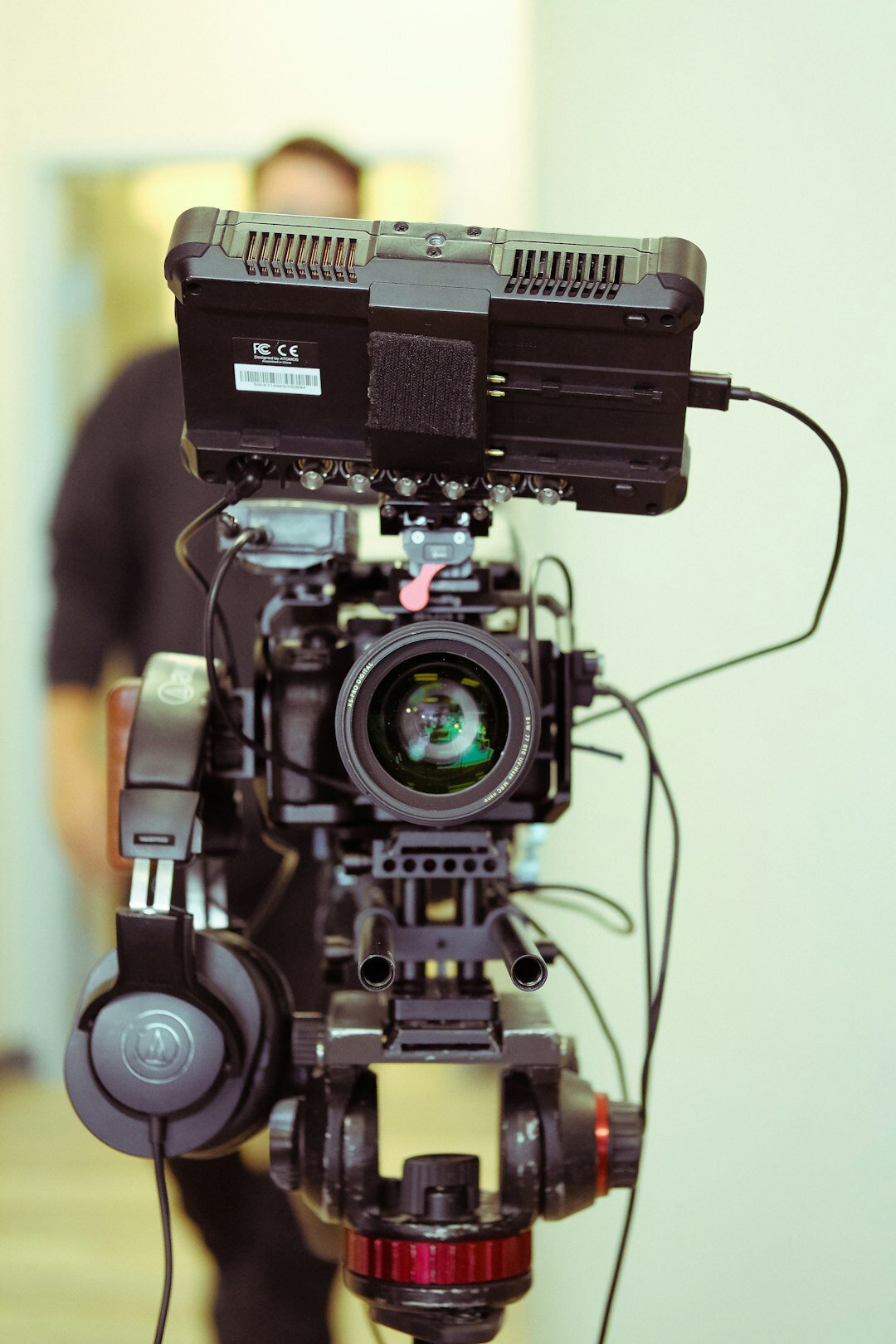 Camera operator filming with a professional broadcast camera on a tripod