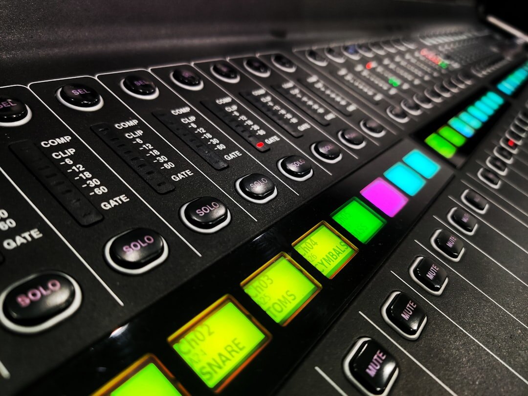 Close-up of a video switcher console with illuminated buttons and sliders